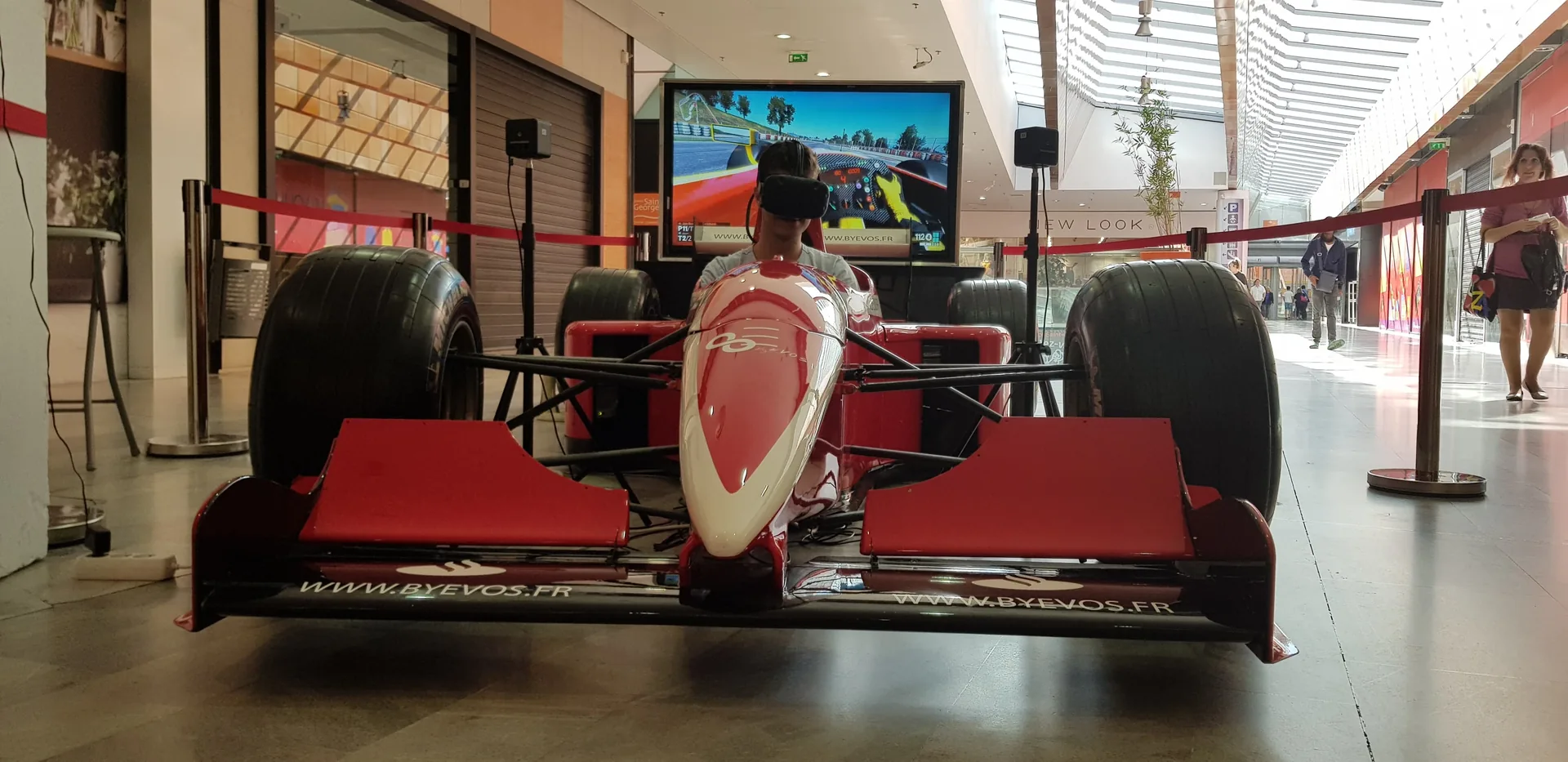 Pilote casque VR dans la monoplace, écran de retransmission